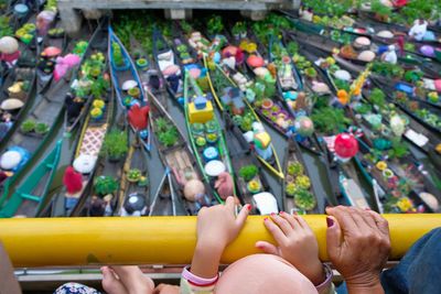 High angle view of people by railing against floating market