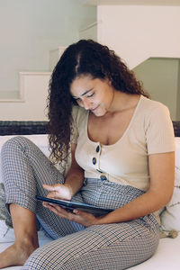 Beautiful young woman using digital tablet at home