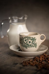 Traditional floral porcelain kopitiam coffee cup with a small jar of milk. malaysian coffee. 