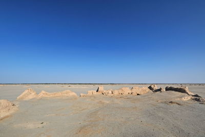 Scenic view of desert against clear blue sky