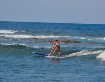 Man surfing in sea against clear sky