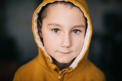 Close-up portrait of boy wearing hooded shirt in home