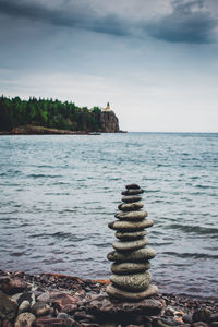 Stack of rocks on beach against sky