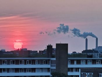 Smoke emitting from chimney against sky at sunset