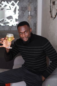 Portrait of a young man drinking glass