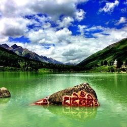 Scenic view of lake and mountains against cloudy sky