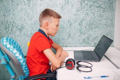 Side view of boy using mobile phone