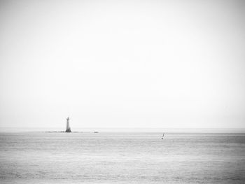 View of sailboat in sea against clear sky