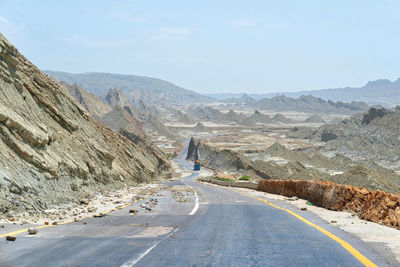 Road leading towards mountains against sky