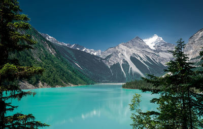 Scenic view of lake and mountains against blue sky