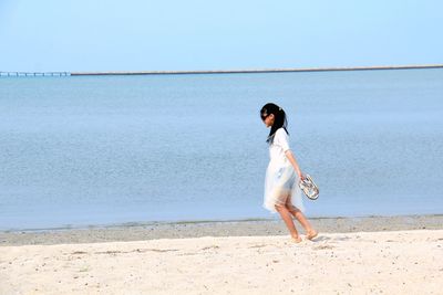 Side view of girl walking at beach