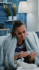 Woman looking at camera while sitting on table