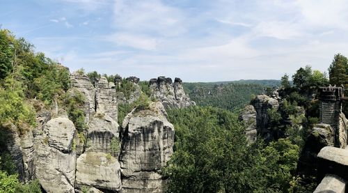 Panoramic view of trees on landscape against cloudy sky