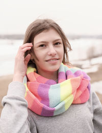 Beautiful teenager girl wearing festive multicolored scarf and looking at camera. outdoors walking.