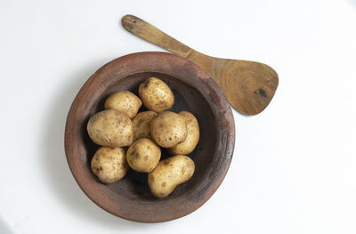 Close-up of potatoes in bowl on white background