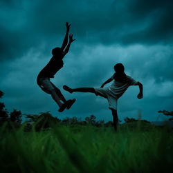 Low angle view of people on field against sky