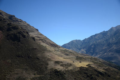 Scenic view of mountains against clear blue sky