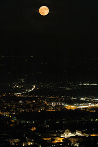 Aerial view of illuminated cityscape against sky at night