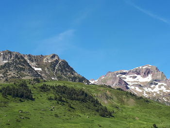 Scenic view of mountains against blue sky