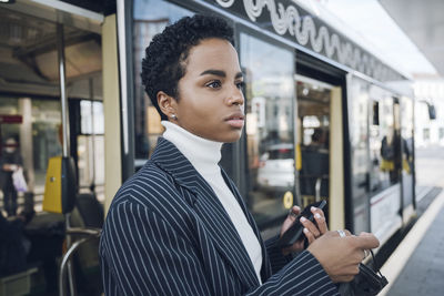 Young man using mobile phone in bus