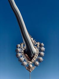 Low angle view of metallic structure against clear blue sky