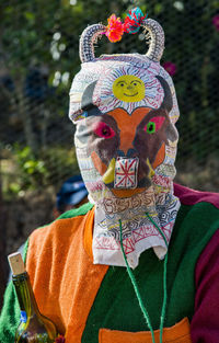 Close-up portrait of man wearing multi colored umbrella
