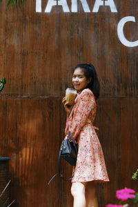 Portrait of a smiling young woman standing outdoors