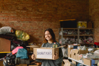 Volunteer teengirl preparing donation boxes for people.