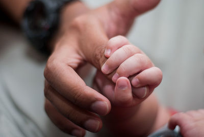 Close-up of cropped hand holding baby