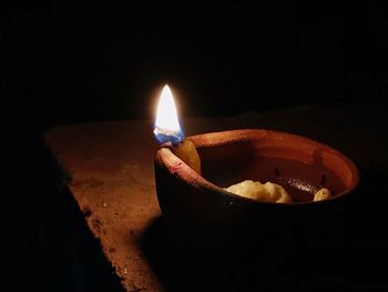 Close-up of illuminated light candle against black background