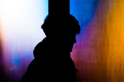 Silhouette man standing against illuminated stage at night