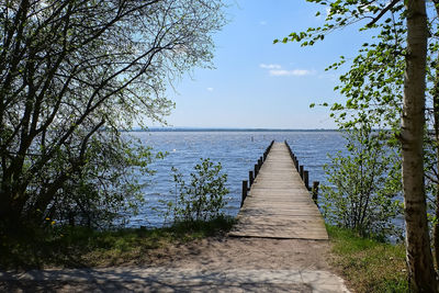 View of wooden footpath leading towards sea