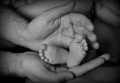 Midsection of mother holding baby hand