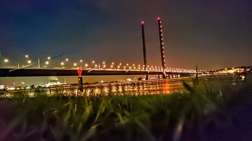 Illuminated bridge against sky at night