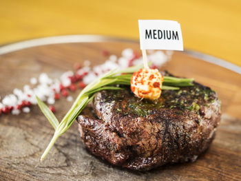 Close-up of filet mignon with text on cutting board