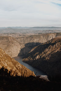 Scenic view of river amidst mountains against sky