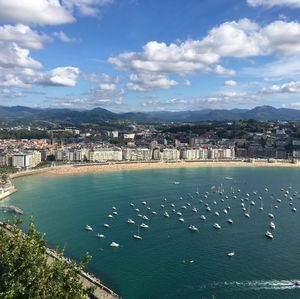 High angle view of city by sea against sky