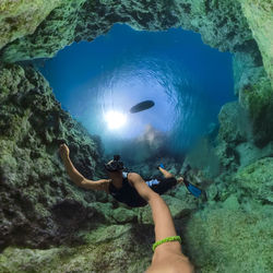 Man scuba diving by corals in sea