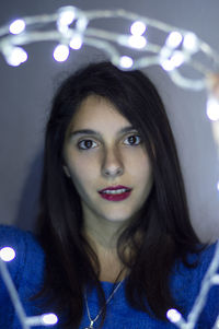 Close-up portrait of young woman with illuminated lights