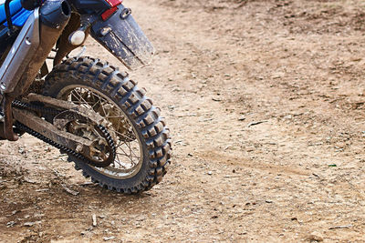 Close-up of motorcycle on dirt road