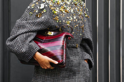 Midsection of woman standing against wall