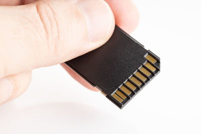 High angle view of hand holding camera over white background