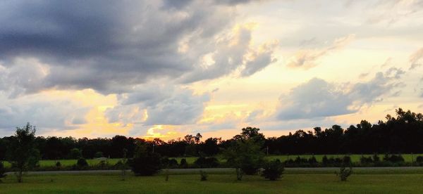 Scenic view of grassy field against cloudy sky