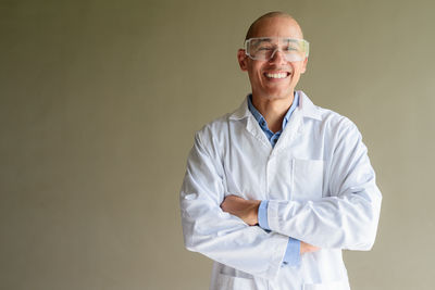 Midsection of doctor standing against white background