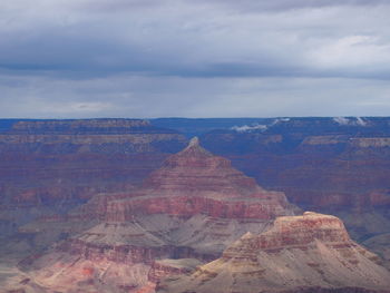Rock formations on landscape against cloudy sky