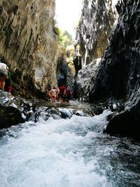 Group of people on rock by river