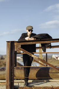 Full length of young man against railing against sky