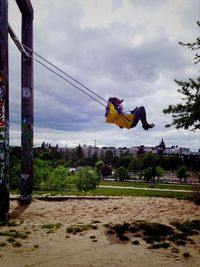 Low angle view of man jumping against sky