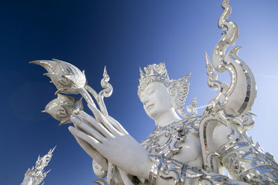 Low angle view of angel statue against clear blue sky