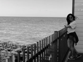 Full length portrait of young woman standing in balcony